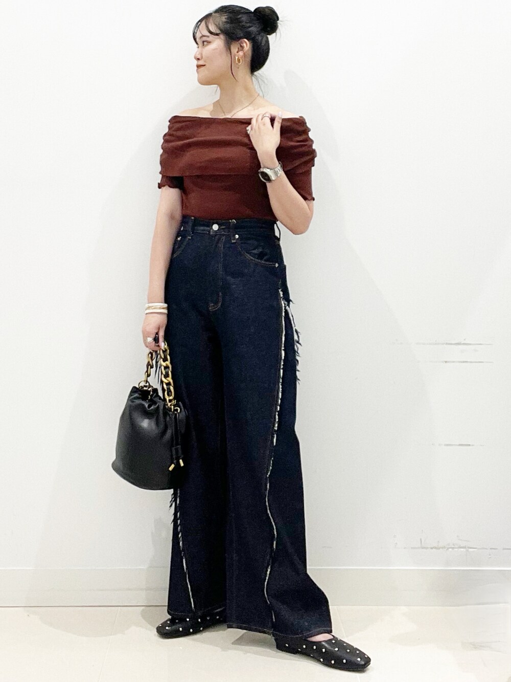 ブルー系のデニムパンツ、ブラック系のショルダーバッグ、ブラック系のパンプスを着用したレディースの夏コーディネートの2枚目の写真