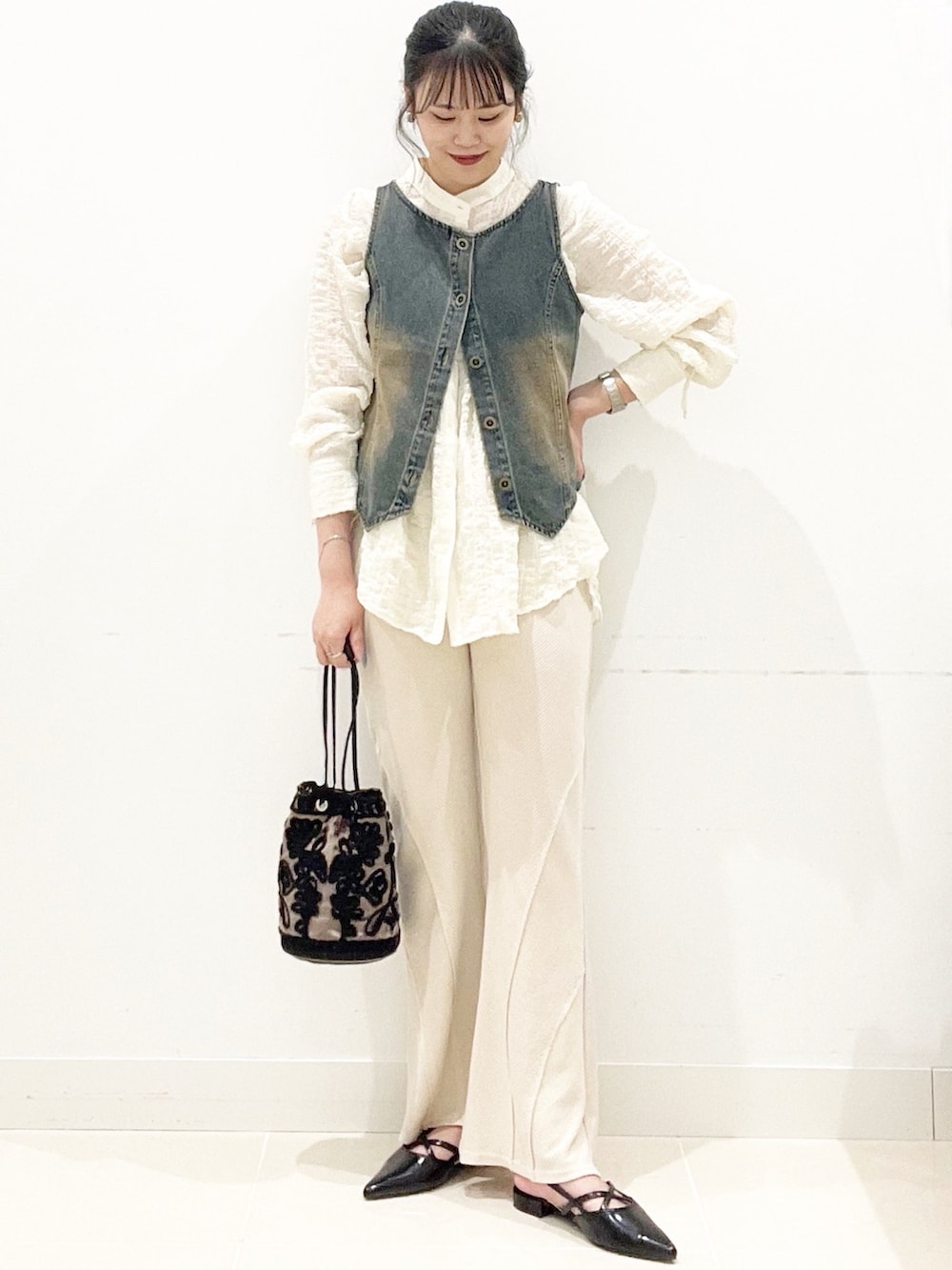 ブラウン系のハンドバッグ、ベージュ系のその他パンツ、ブラック系のその他シューズを着用したレディースの秋コーディネートの5枚目の写真