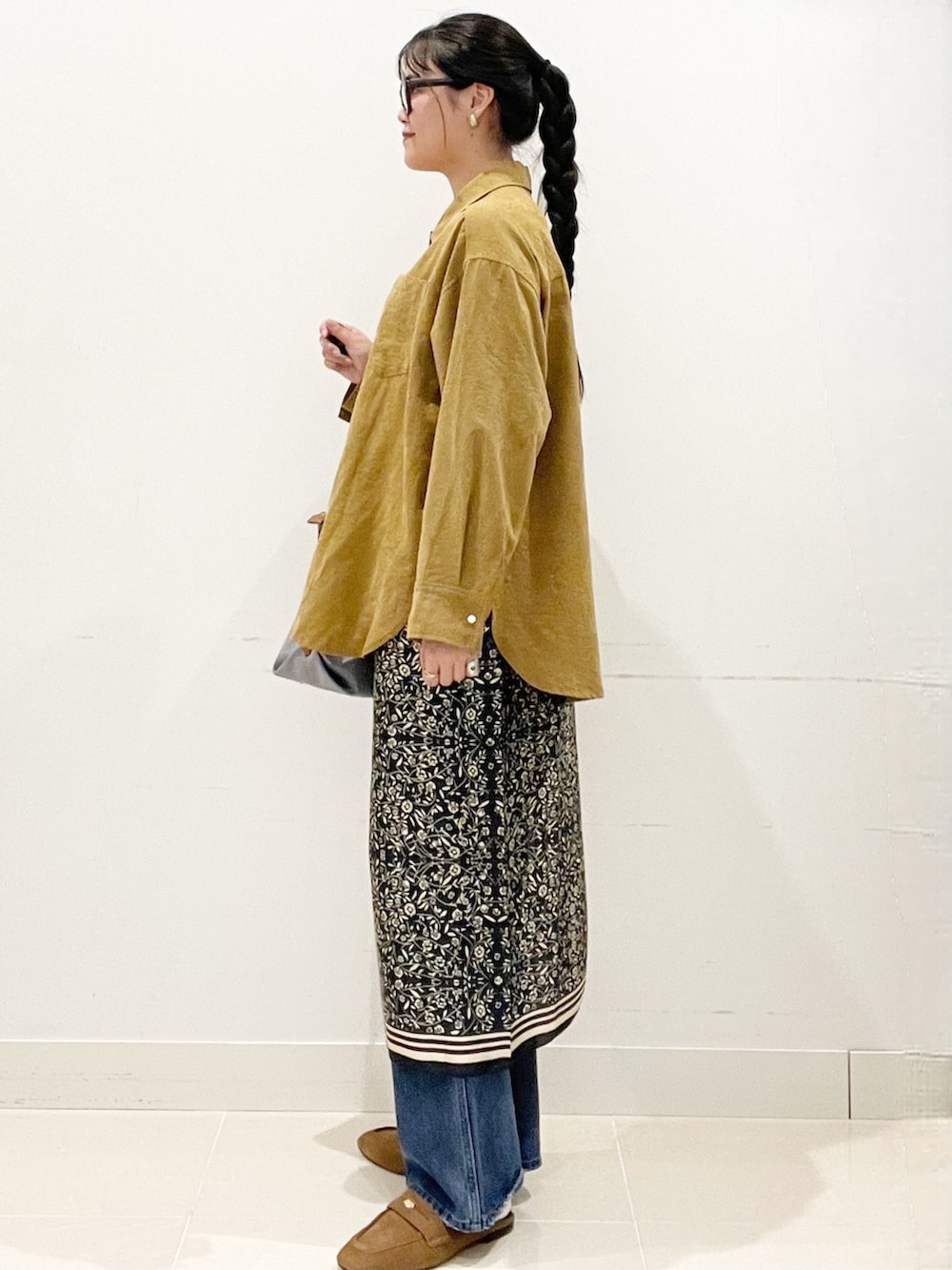 ブルー系のデニムパンツ、グレー系のトートバッグ、イエロー系のシャツ/ブラウスを着用したレディースの冬コーディネートの4枚目の写真