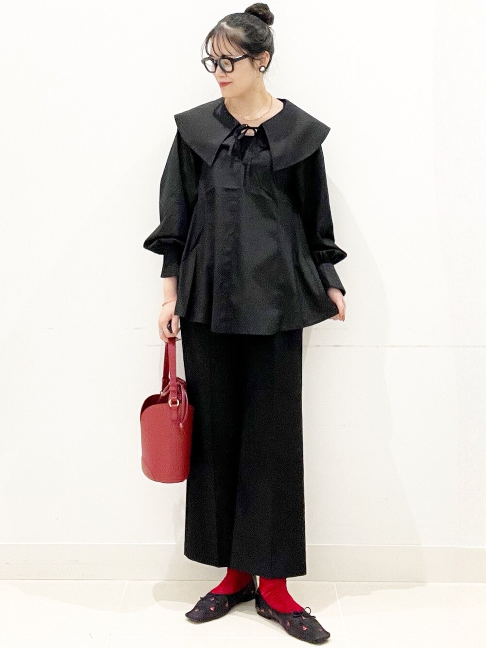 ブラック系のバレエシューズ、ブラック系のその他パンツ、レッド系のハンドバッグを着用したレディースの秋コーディネートの2枚目の写真