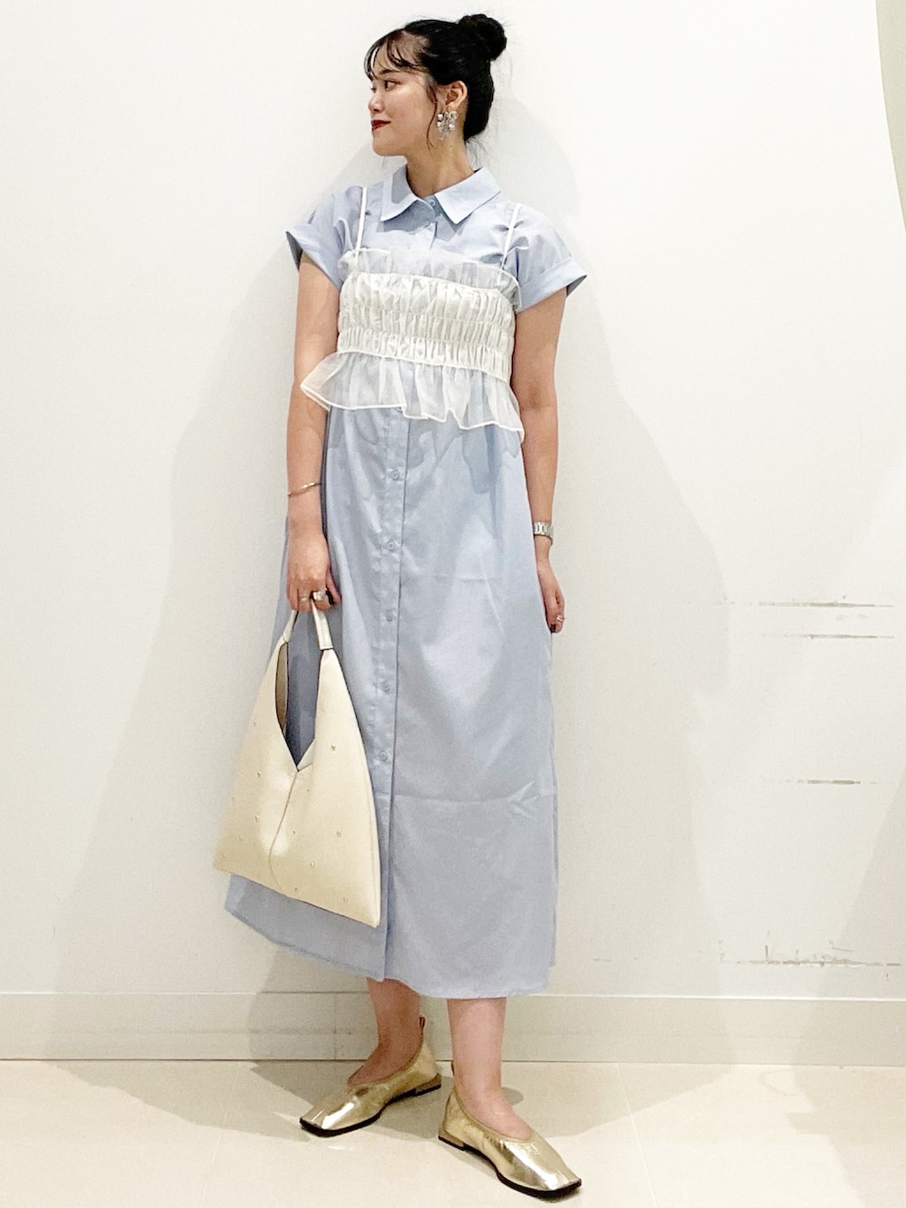 ホワイト系のトートバッグ、ブルー系のワンピース、ゴールド系のバレエシューズを着用したレディースの秋コーディネートの2枚目の写真