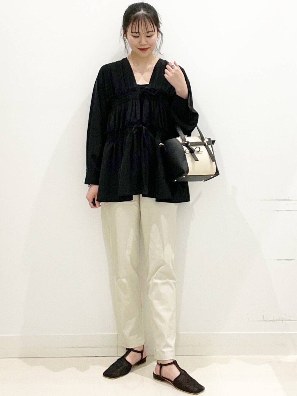 ベージュ系のその他パンツ、ブラック系のトートバッグ、ブラック系のキャミソールを着用したレディースの春コーディネートの4枚目の写真