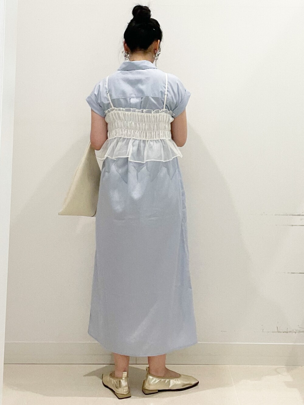 ホワイト系のトートバッグ、ブルー系のワンピース、ゴールド系のバレエシューズを着用したレディースの秋コーディネートの6枚目の写真