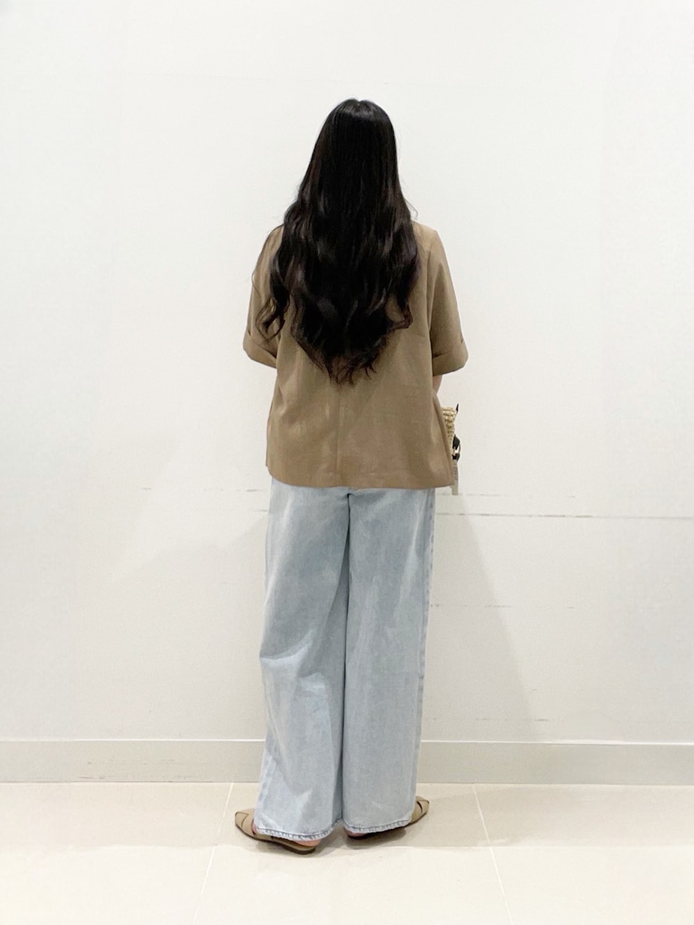 ベージュ系のテーラードジャケット、ホワイト系のTシャツ/カットソー、ブルー系のデニムパンツを着用したレディースの夏コーディネートの5枚目の写真
