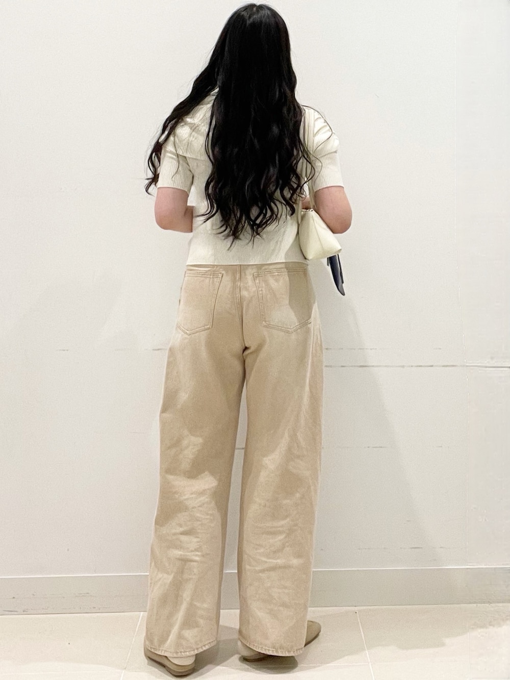 ベージュ系のローファー、ベージュ系のデニムパンツ、ホワイト系のニット/セーターを着用したレディースの春コーディネートの4枚目の写真