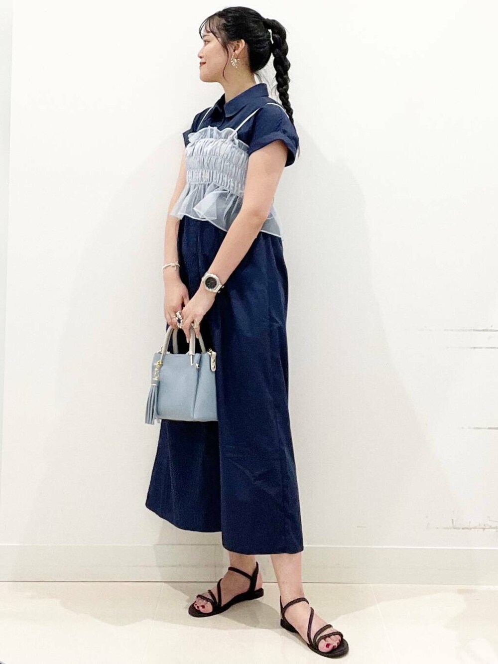 ブルー系のトートバッグ、ブラック系のサンダル、ブルー系のワンピースを着用したレディースの夏コーディネートの3枚目の写真