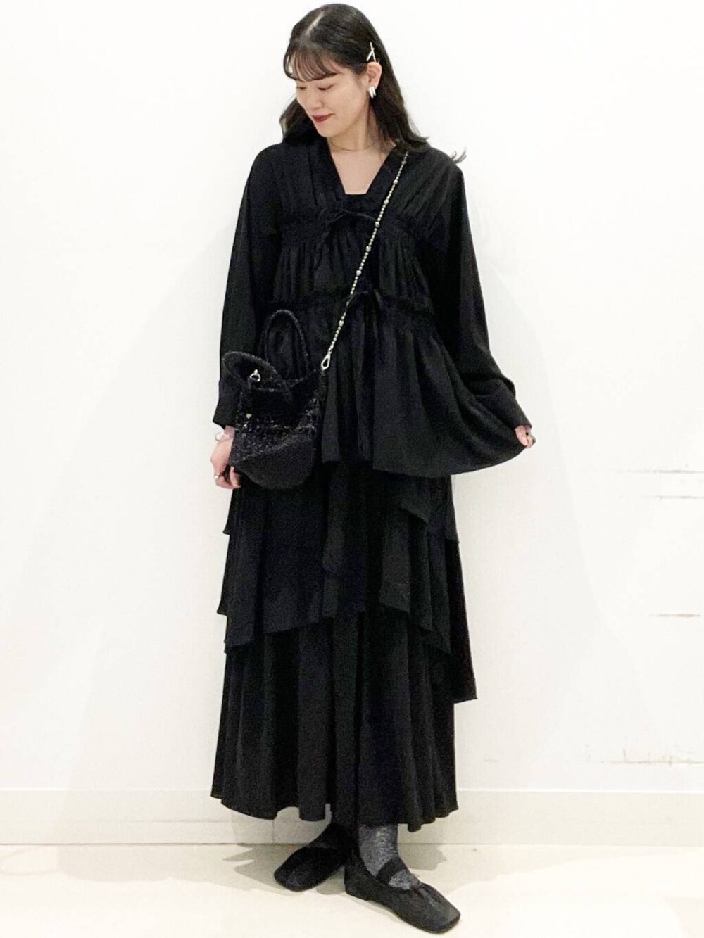 ブラック系のショルダーバッグ、ブラック系のキャミソール、ブラック系のパンプスを着用したレディースの春コーディネートの4枚目の写真