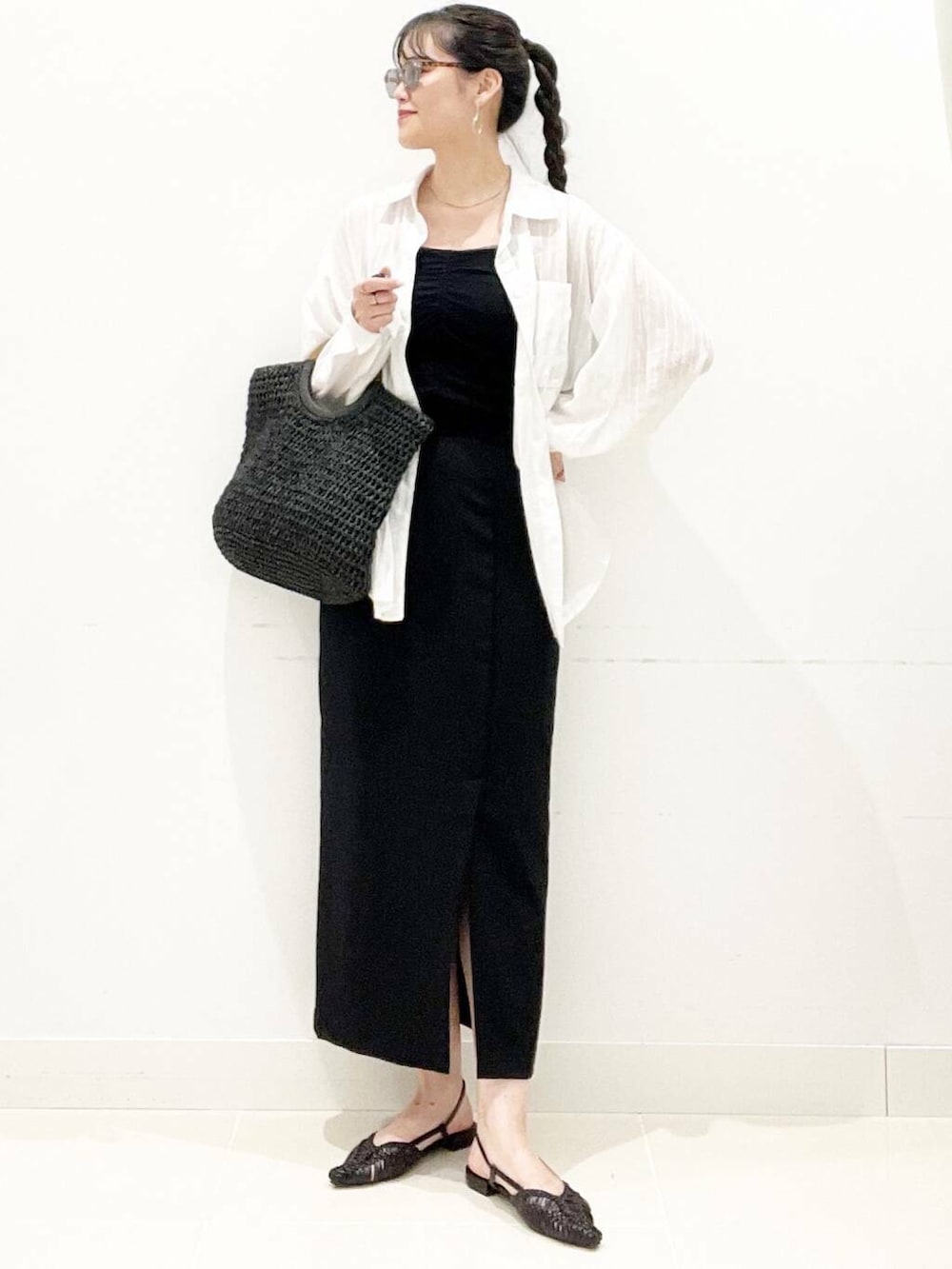 ブラック系のキャミソール、ブラック系のトートバッグ、ブラック系のサンダルを着用したレディースの夏コーディネートの3枚目の写真