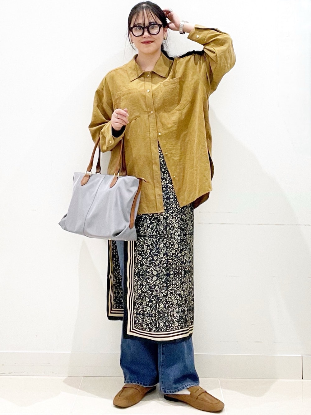 ブルー系のデニムパンツ、グレー系のトートバッグ、イエロー系のシャツ/ブラウスを着用したレディースの冬コーディネートの3枚目の写真