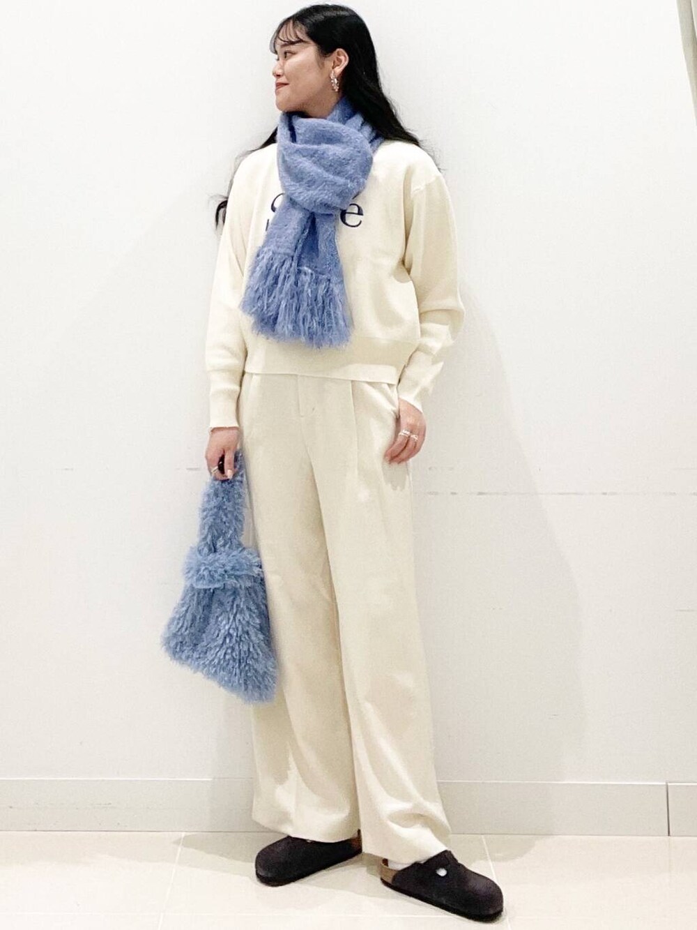 ブルー系のハンドバッグ、ホワイト系のその他パンツ、ホワイト系のニット/セーターを着用したレディースの冬コーディネートの4枚目の写真