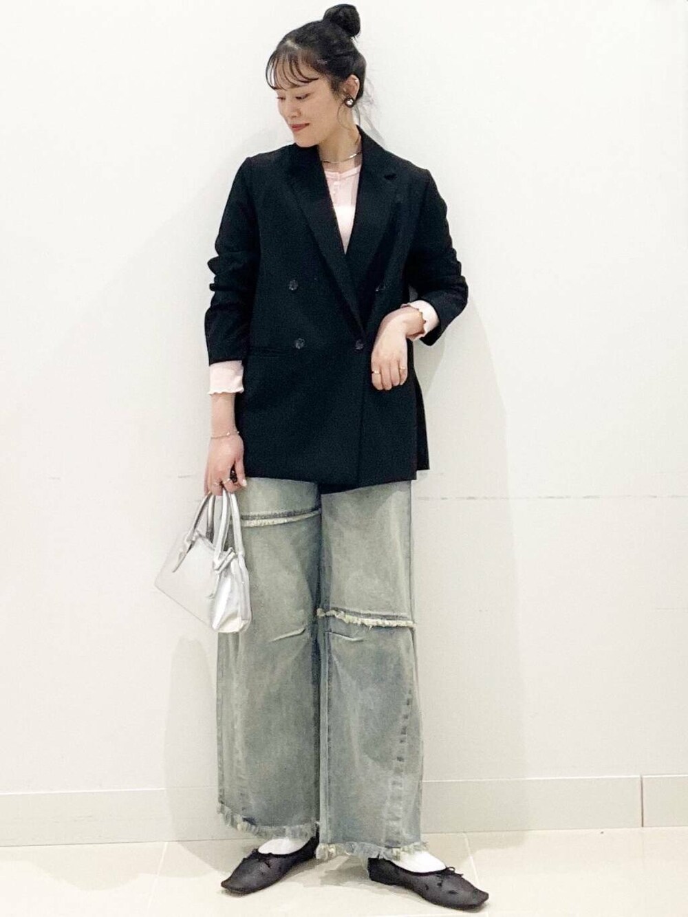 ブラック系のバレエシューズ、シルバー系のボストンバッグ、ブルー系のデニムパンツを着用したレディースの春コーディネートの2枚目の写真