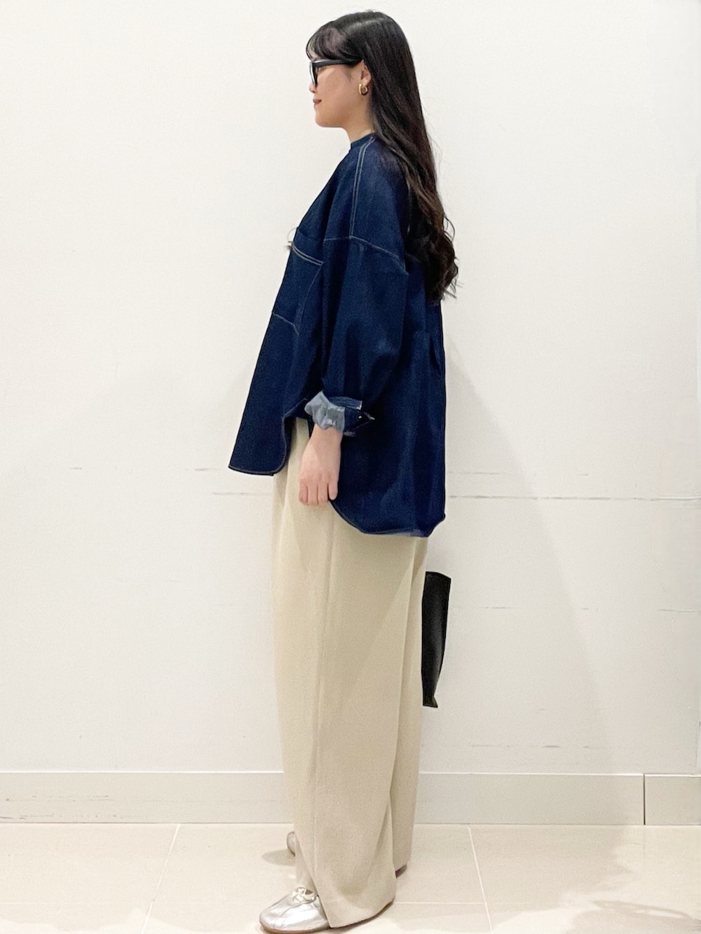 ベージュ系のスラックス、ブラック系のトートバッグ、ブルー系のシャツ/ブラウスを着用したレディースの春コーディネートの5枚目の写真