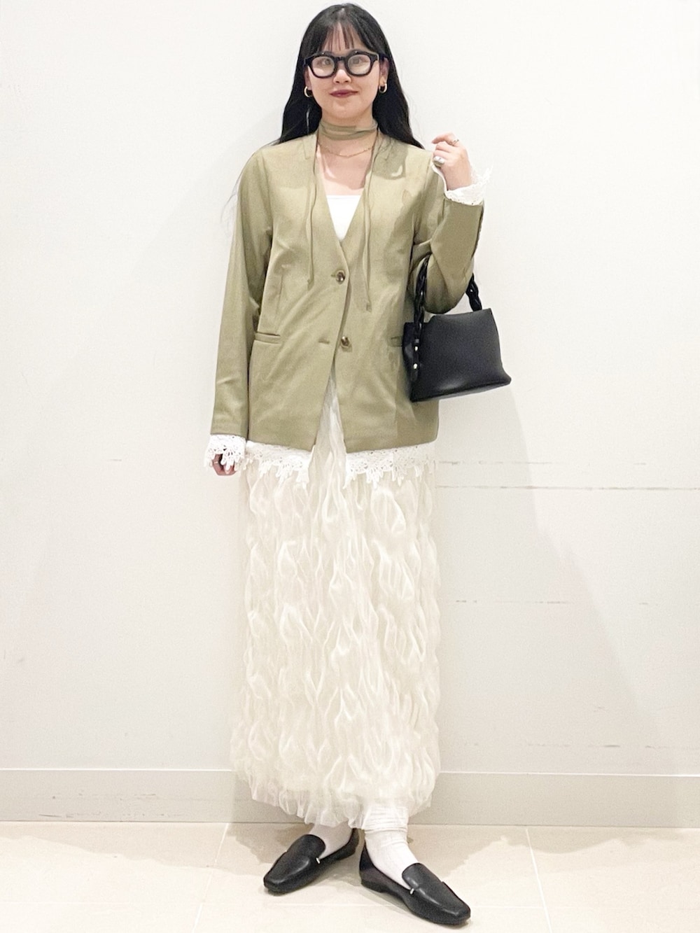 ブラック系のローファー、ホワイト系のスカート、ベージュ系のノーカラージャケットを着用したレディースの春コーディネートの2枚目の写真
