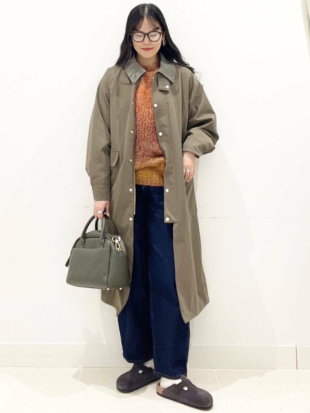 グリーン系のボストンバッグ、ブルー系のデニムパンツ、ブラウン系のその他アウターを着用したレディースの秋コーディネートの4枚目の写真