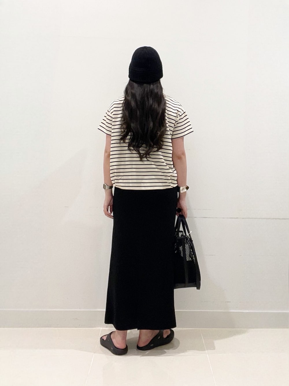 ホワイト系のTシャツ/カットソー、ブラック系のスカート、ブラック系のトートバッグを着用したレディースの夏コーディネートの6枚目の写真