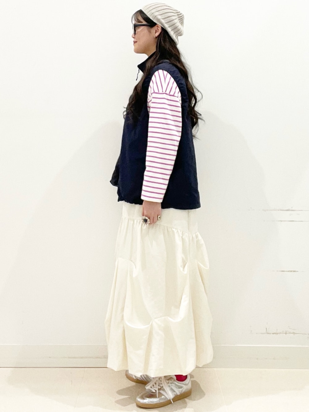 シルバー系のスニーカー、ホワイト系のスカート、ブルー系のナイロンジャケットを着用したレディースの春コーディネートの6枚目の写真