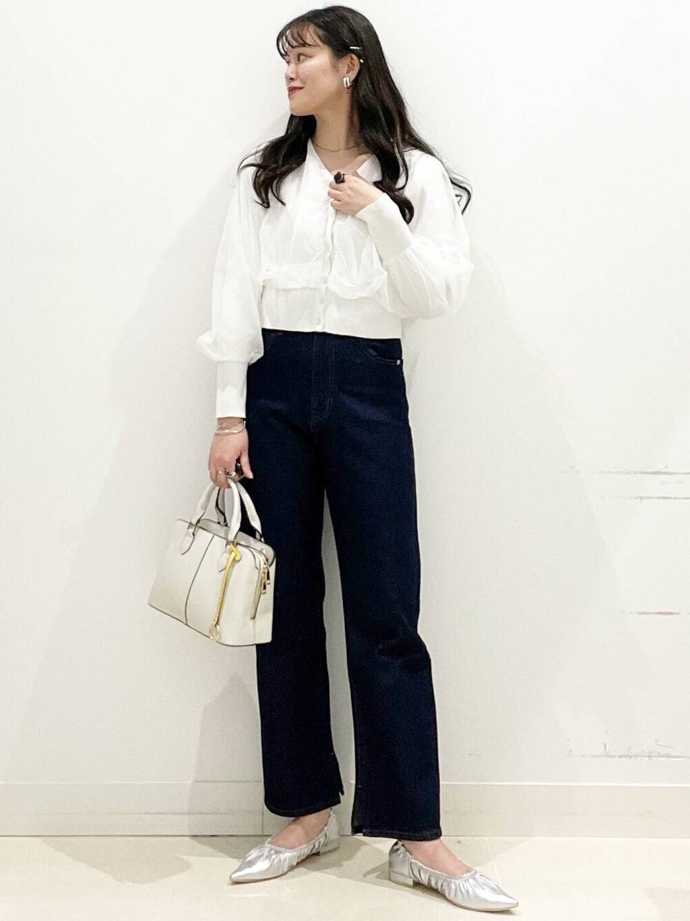 ブルー系のデニムパンツ、シルバー系のバレエシューズ、ホワイト系のカーディガン/ボレロを着用したレディースの春コーディネートの2枚目の写真