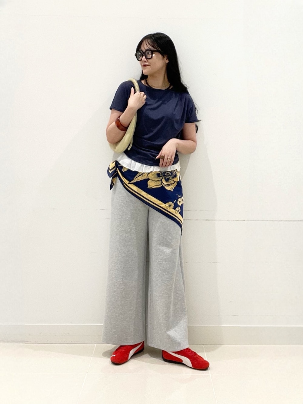 グレー系のスラックス、レッド系のスニーカー、ベージュ系のハンドバッグを着用したレディースの夏コーディネートの6枚目の写真