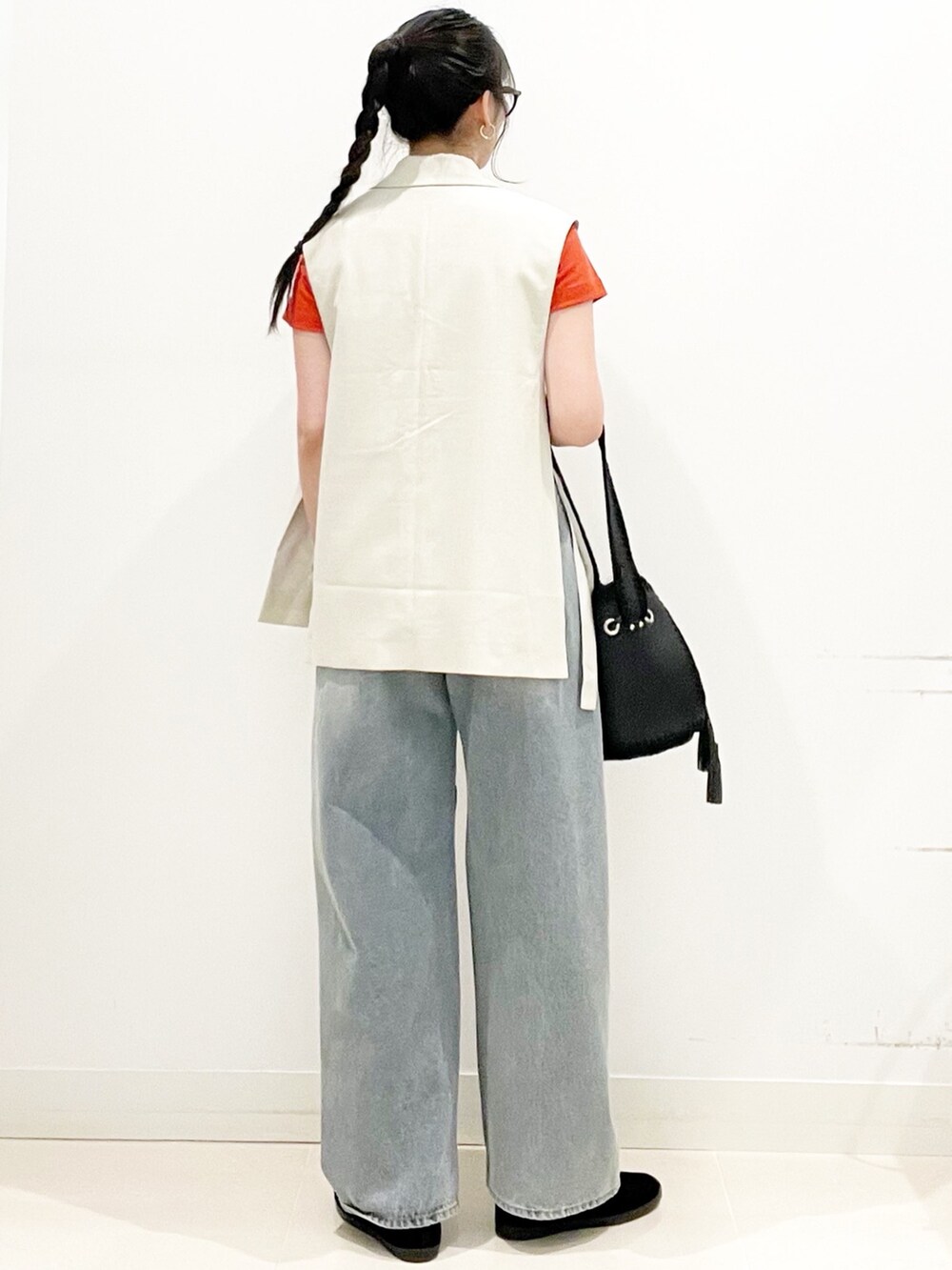 ベージュ系のベスト、レッド系のTシャツ/カットソー、ブルー系のデニムパンツを着用したレディースの夏コーディネートの6枚目の写真