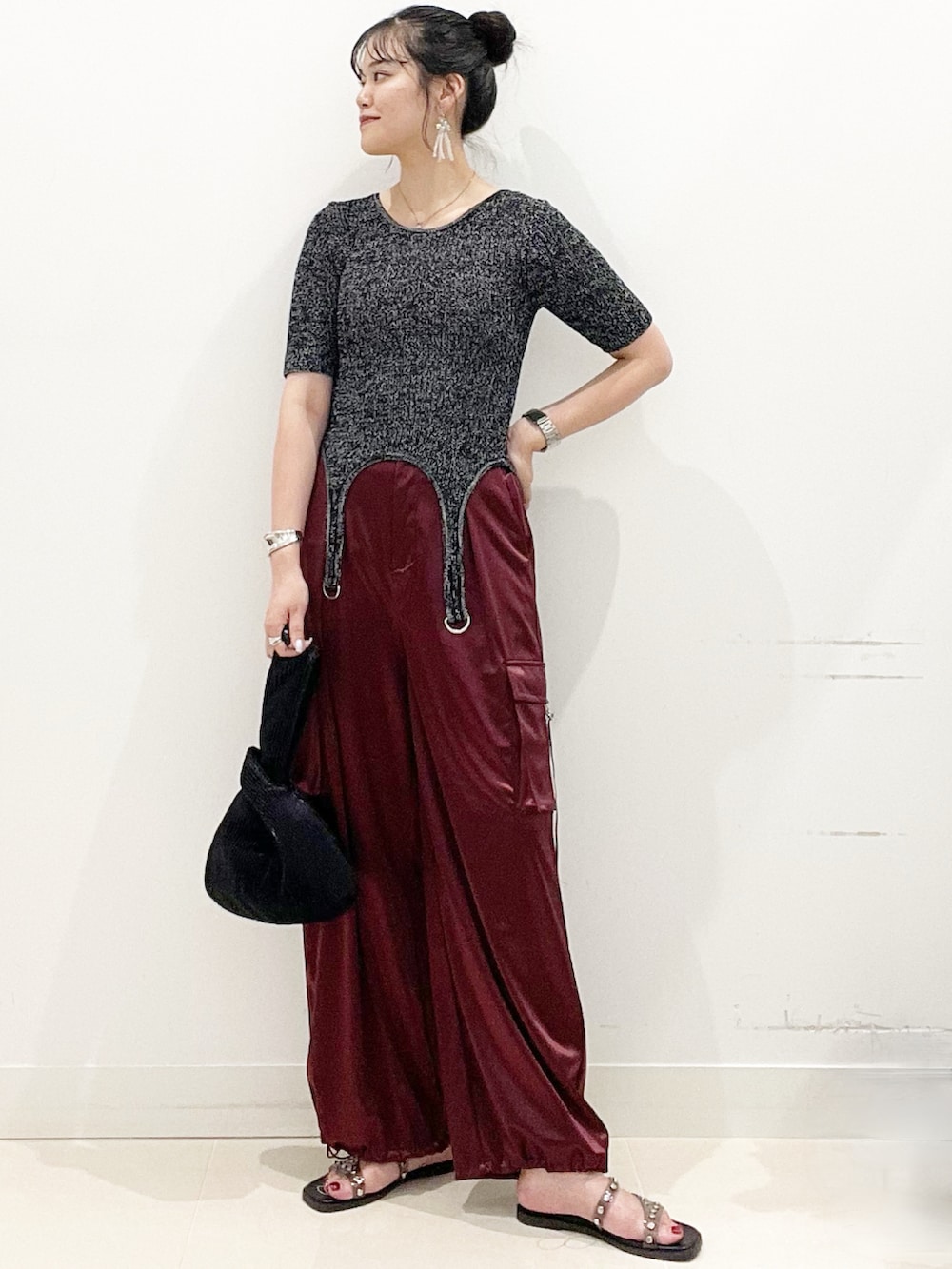 ブラック系のサンダル、ブラック系のハンドバッグ、レッド系のカーゴパンツを着用したレディースの夏コーディネートの3枚目の写真