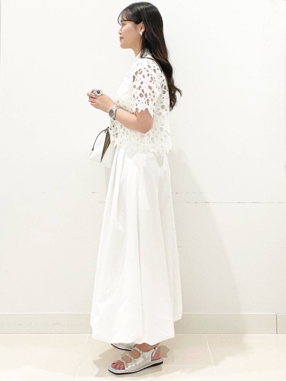 ホワイト系のスカート、ホワイト系のキャミソール、ホワイト系のハンドバッグを着用したレディースの夏コーディネートの5枚目の写真
