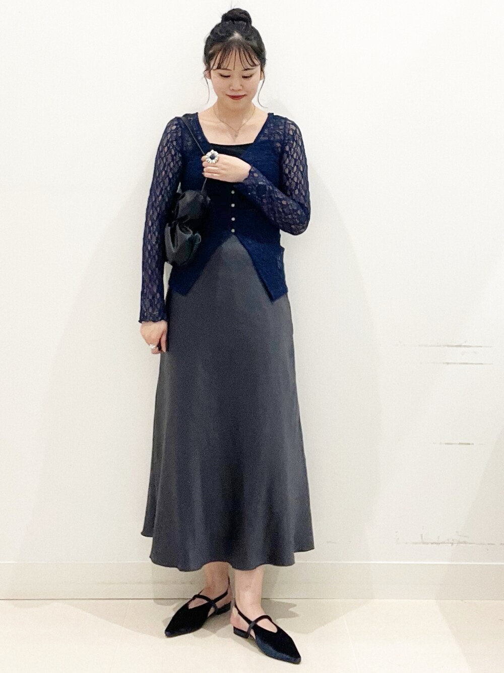 ブラック系のキャミソール、ブラック系のハンドバッグ、ブルー系のパンプスを着用したレディースの秋コーディネートの5枚目の写真