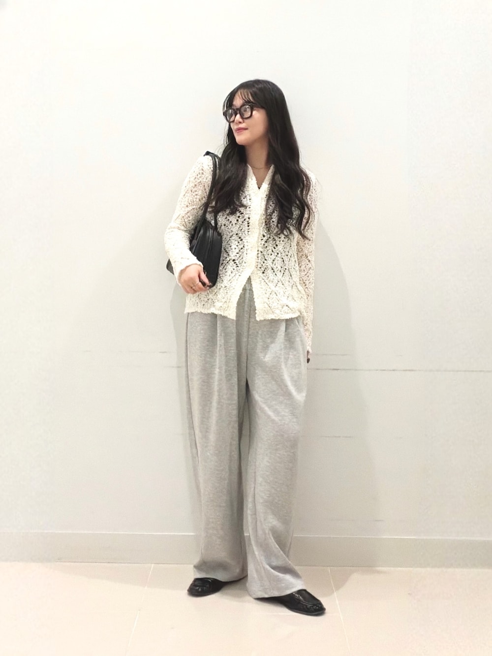 グレー系のその他パンツ、ホワイト系のニット/セーター、ブラック系のボストンバッグを着用したレディースの秋コーディネートの3枚目の写真