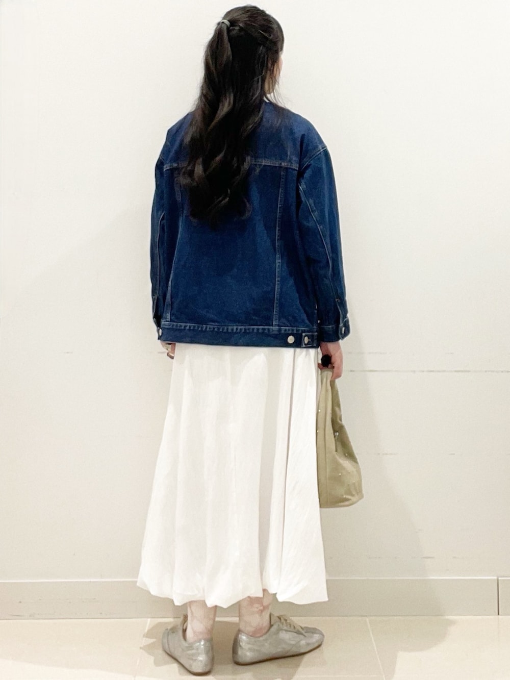 ホワイト系のスカート、ベージュ系のハンドバッグ、ピンク系のTシャツ/カットソーを着用したレディースの春コーディネートの4枚目の写真