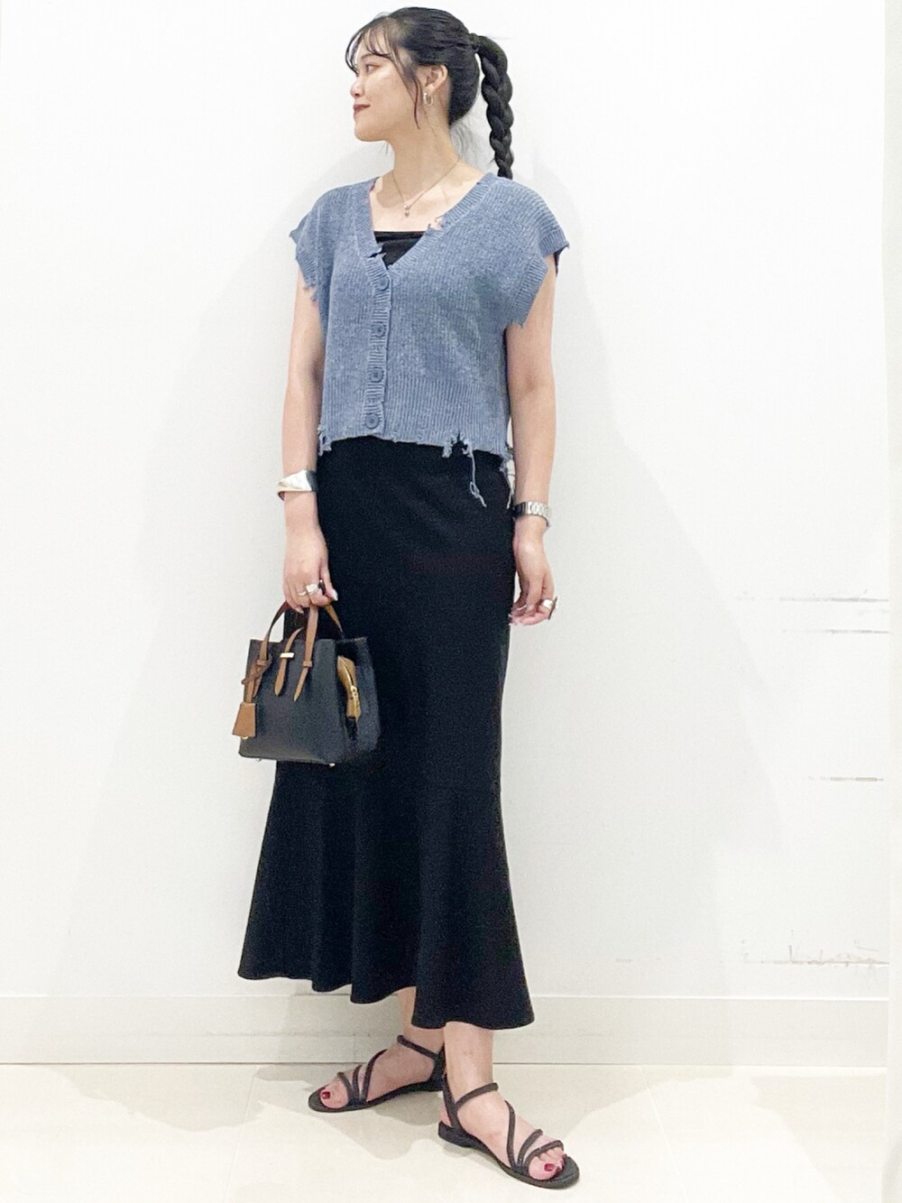 ブラック系のハンドバッグ、ブラック系のキャミソール、ブラック系のサンダルを着用したレディースの夏コーディネートの3枚目の写真