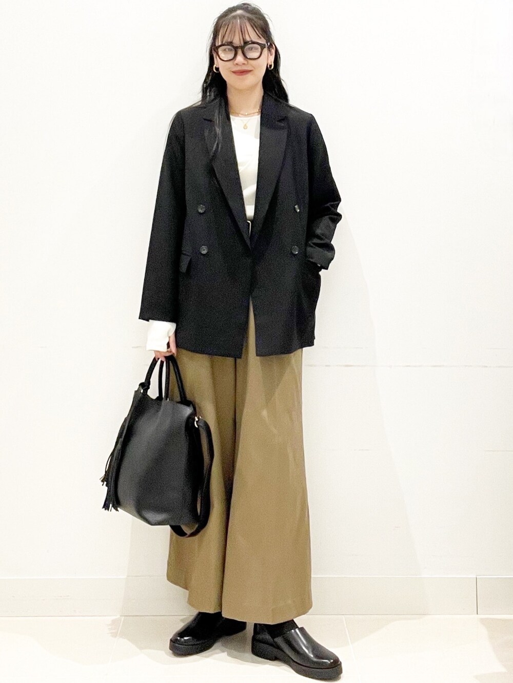 ベージュ系のその他パンツ、ブラック系のトートバッグ、ブラック系のその他アウターを着用したレディースの秋コーディネートの2枚目の写真