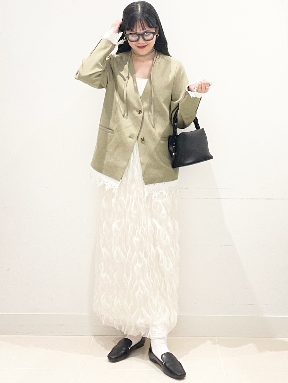 ブラック系のローファー、ホワイト系のスカート、ベージュ系のノーカラージャケットを着用したレディースの春コーディネートの4枚目の写真