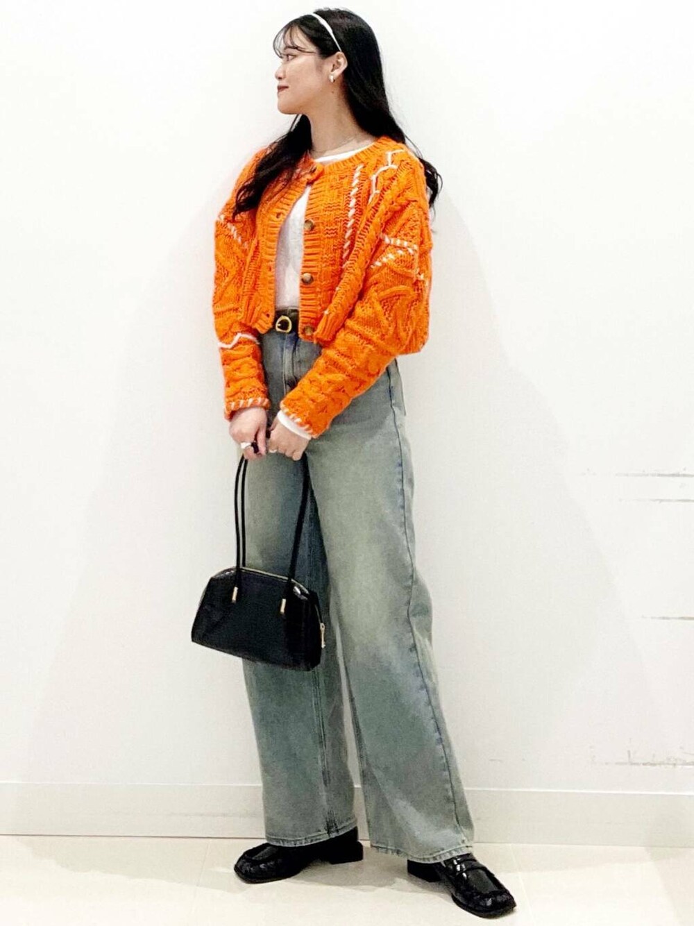 ブラック系のローファー、オレンジ系のカーディガン/ボレロ、ホワイト系のTシャツ/カットソーを着用したレディースの秋コーディネートの2枚目の写真