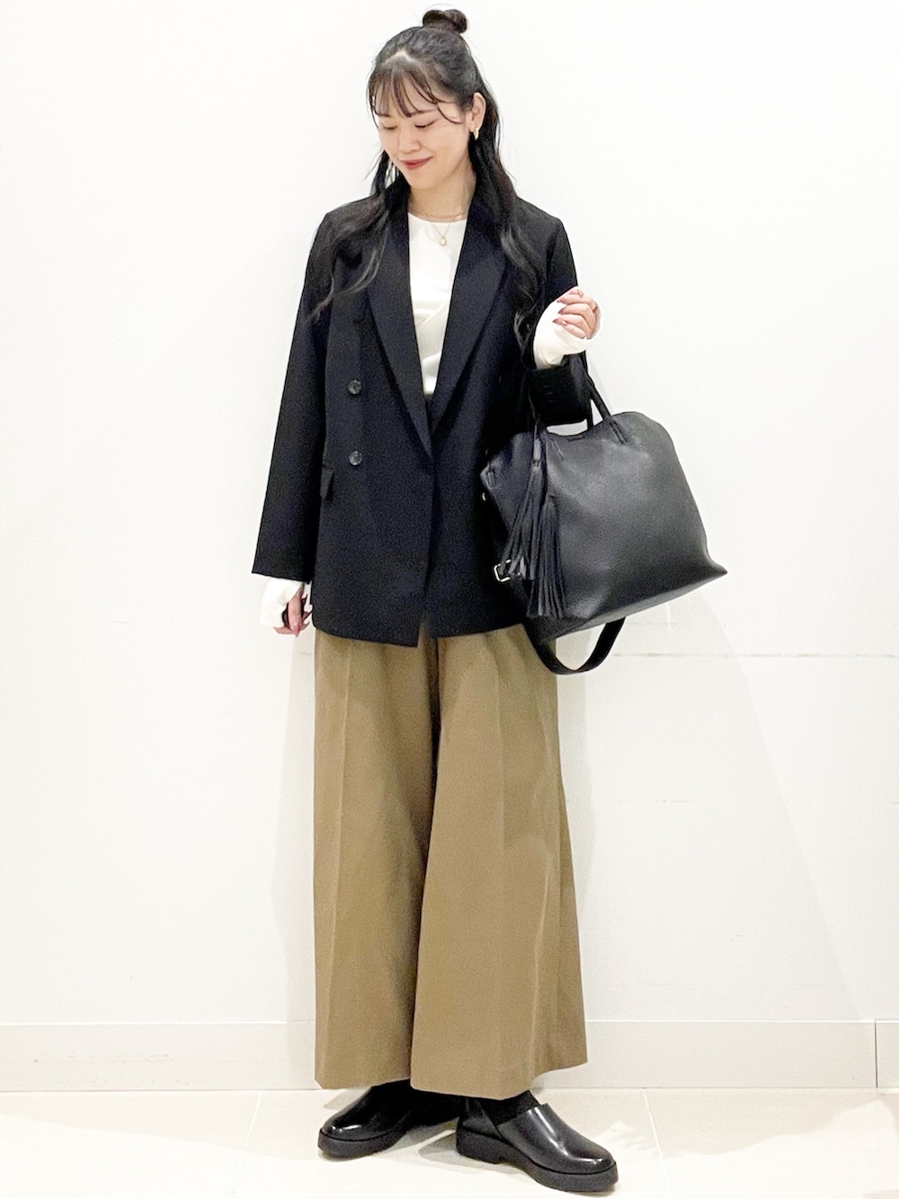 ベージュ系のその他パンツ、ブラック系のトートバッグ、ブラック系のその他アウターを着用したレディースの秋コーディネートの6枚目の写真