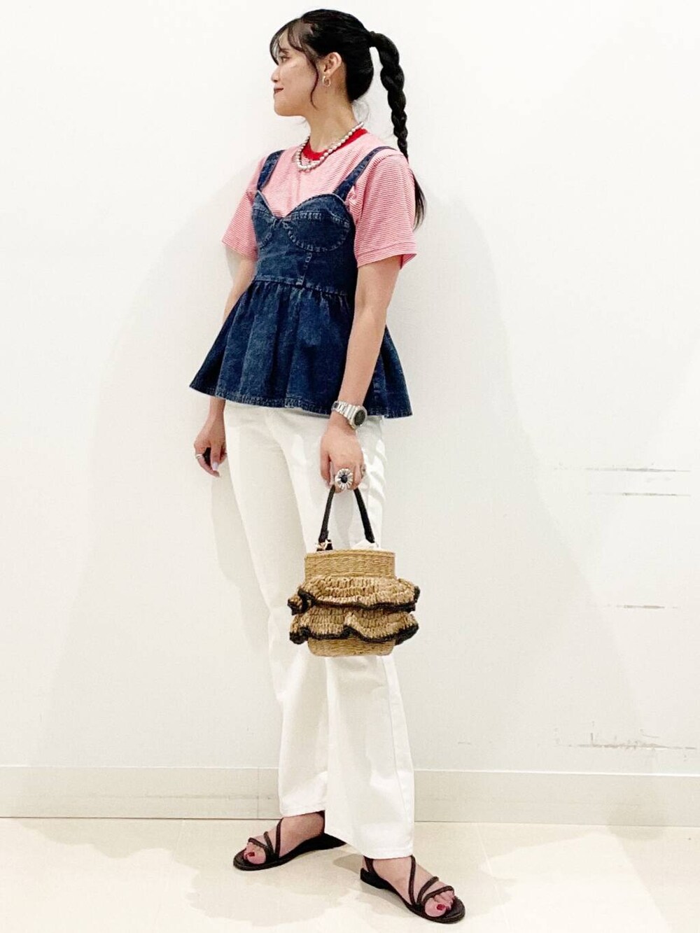 ホワイト系のデニムパンツ、ブラック系のサンダル、ブルー系のベストを着用したレディースの夏コーディネートの2枚目の写真