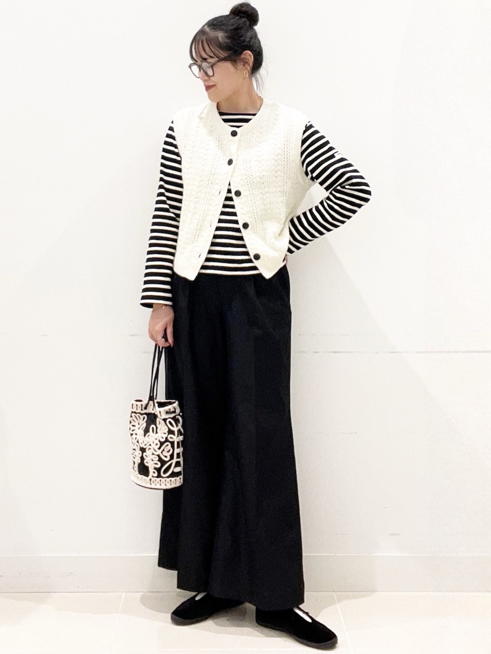 ブラック系のその他シューズ、ブラック系のその他パンツ、ブラック系のハンドバッグを着用したレディースの秋コーディネートの3枚目の写真