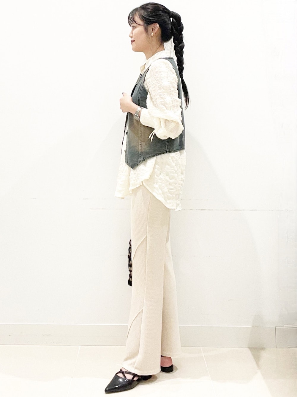 ブラウン系のハンドバッグ、ベージュ系のその他パンツ、ブラック系のその他シューズを着用したレディースの秋コーディネートの6枚目の写真