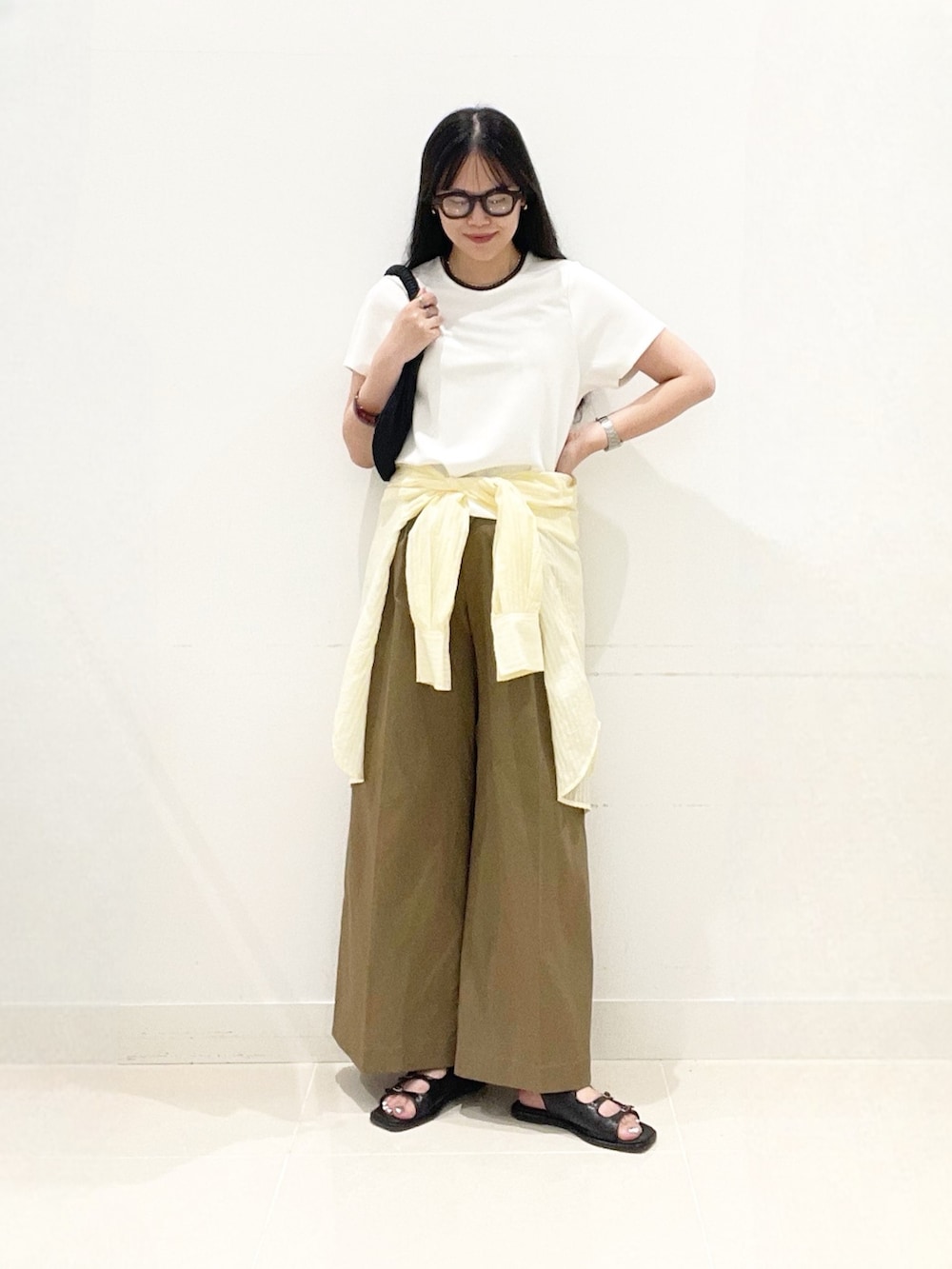 ベージュ系のチノパンツ、ブラック系のサンダル、イエロー系のシャツ/ブラウスを着用したレディースの夏コーディネートの3枚目の写真