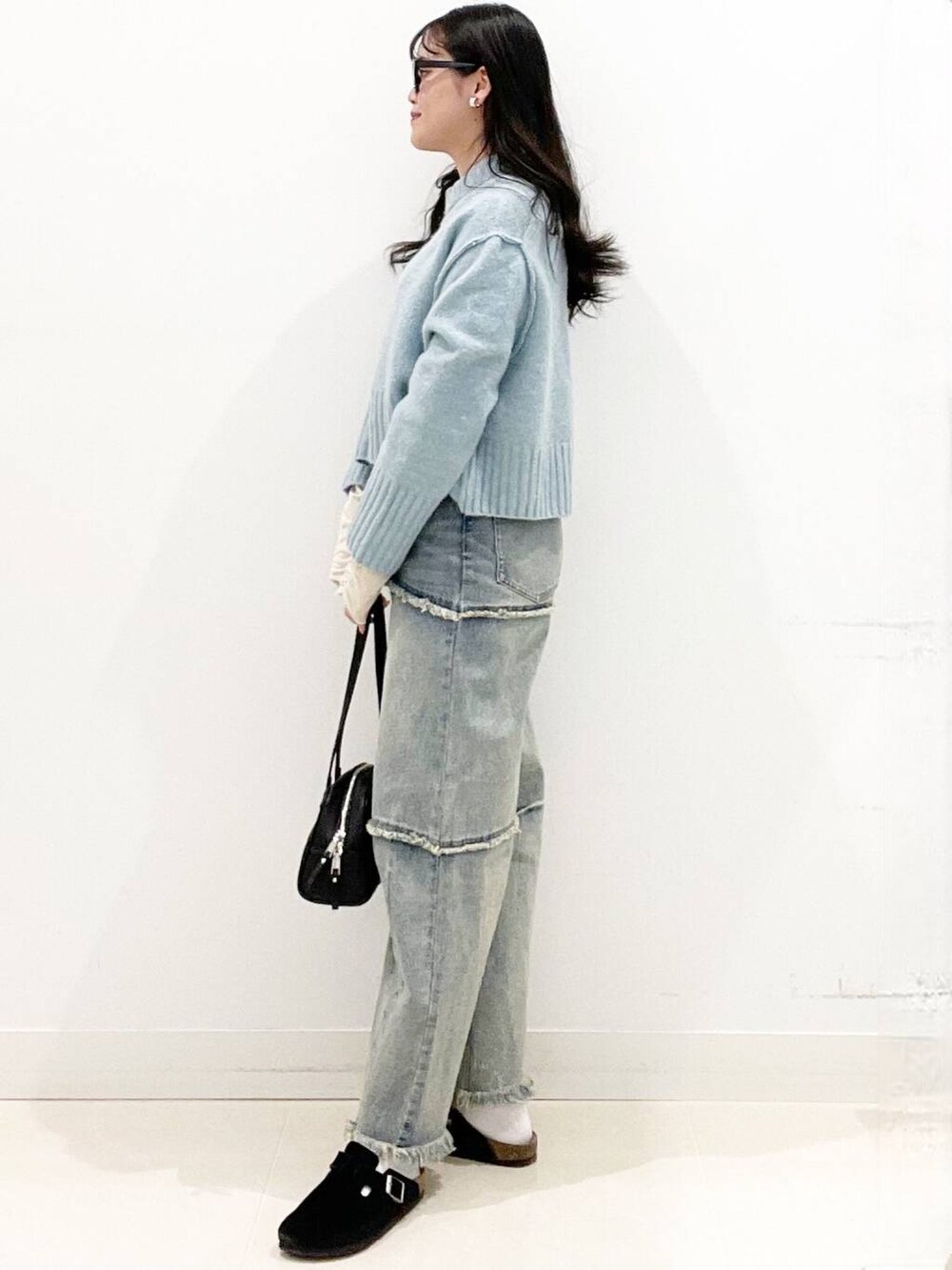 ブラック系のボストンバッグ、ブラック系のサンダル、ブルー系のニット/セーターを着用したレディースの冬コーディネートの4枚目の写真