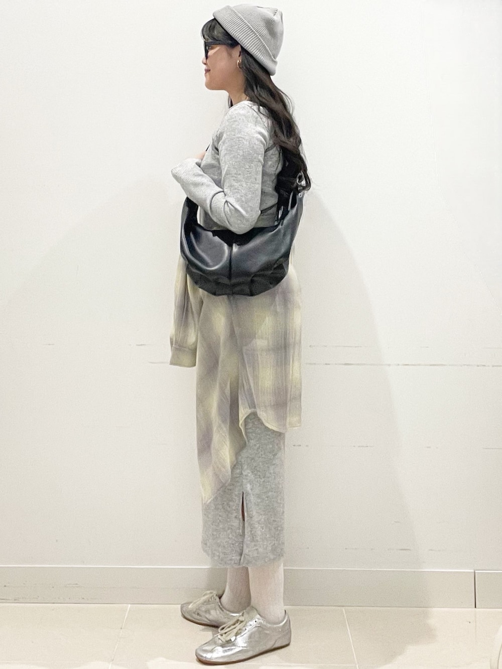 イエロー系のシャツ/ブラウス、グレー系のワンピース、ブラック系のショルダーバッグを着用したレディースの春コーディネートの4枚目の写真