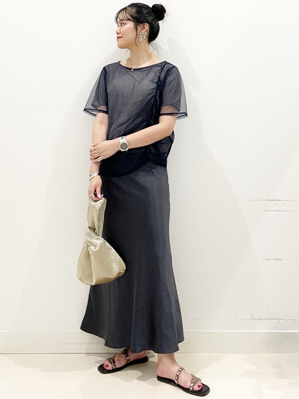 ブラック系のサンダル、ゴールド系のハンドバッグ、ブルー系のTシャツ/カットソーを着用したレディースの夏コーディネートの3枚目の写真