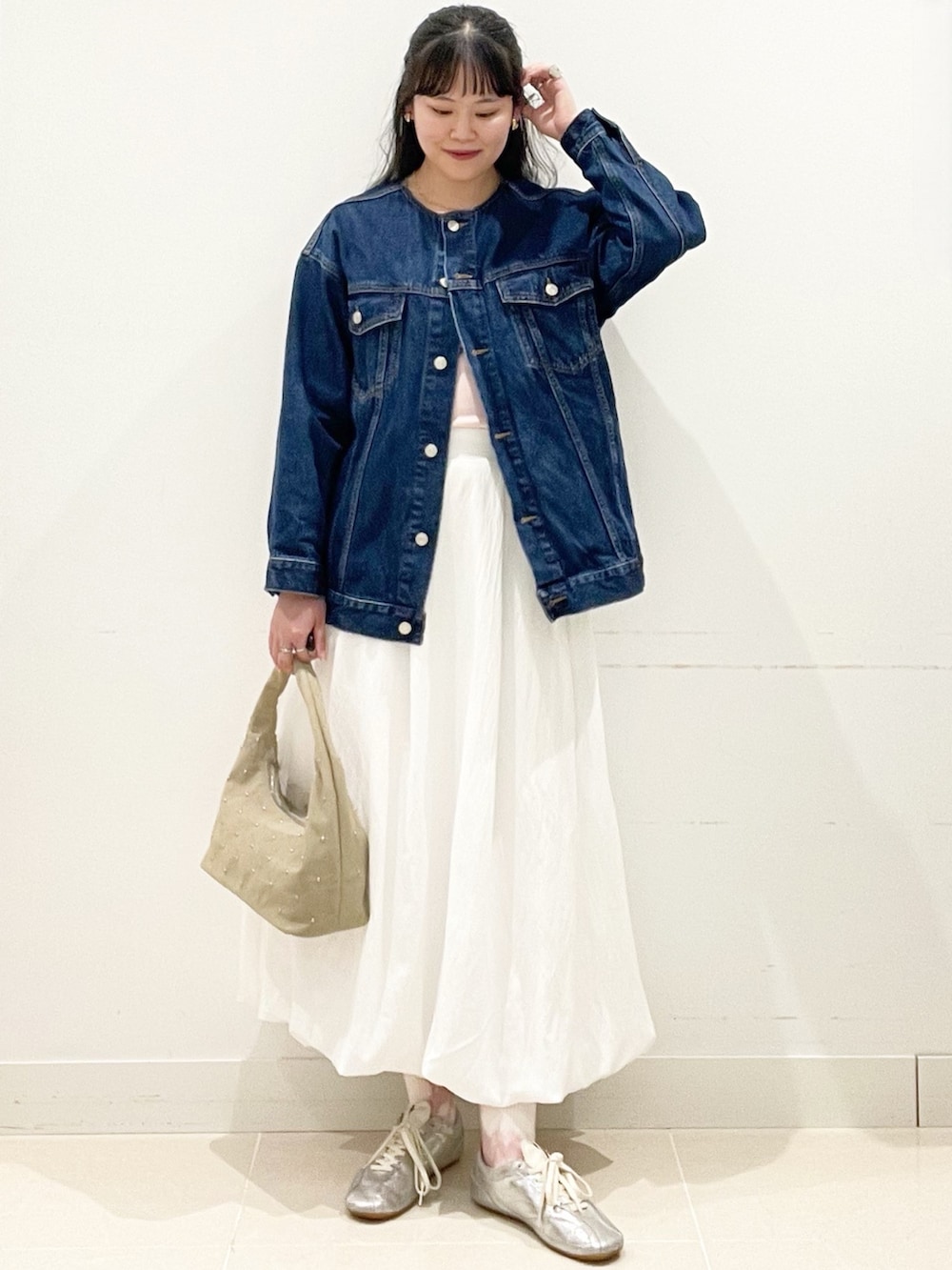 ホワイト系のスカート、ベージュ系のハンドバッグ、ピンク系のTシャツ/カットソーを着用したレディースの春コーディネートの3枚目の写真