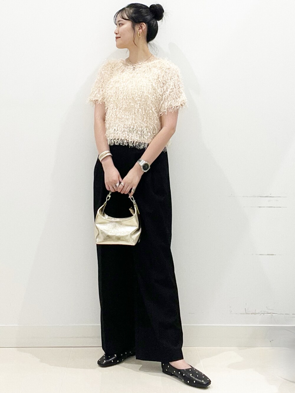 ゴールド系のハンドバッグ、ブラック系のパンプス、オレンジ系のその他トップスを着用したレディースの夏コーディネートの2枚目の写真