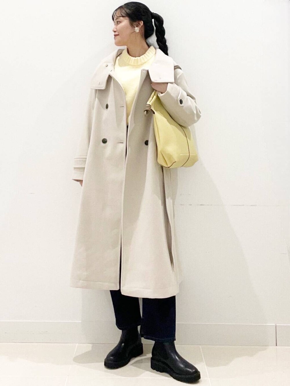 ブラック系のブーツ、ベージュ系のその他アウター、ブルー系のデニムパンツを着用したレディースの冬コーディネートの3枚目の写真