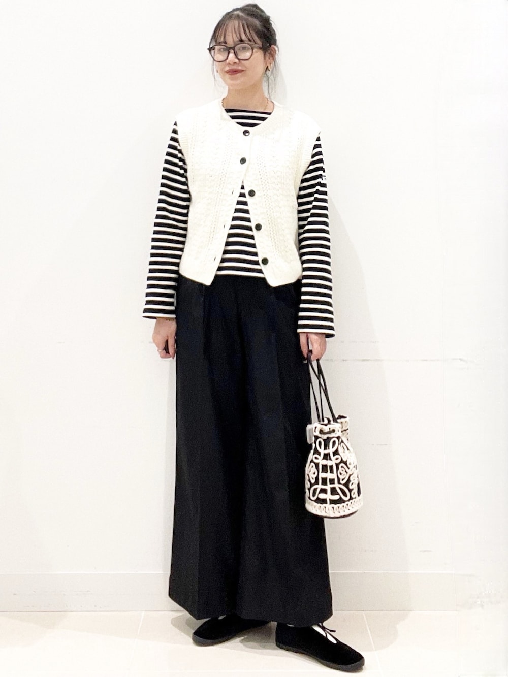 ブラック系のその他シューズ、ブラック系のその他パンツ、ブラック系のハンドバッグを着用したレディースの秋コーディネートの2枚目の写真