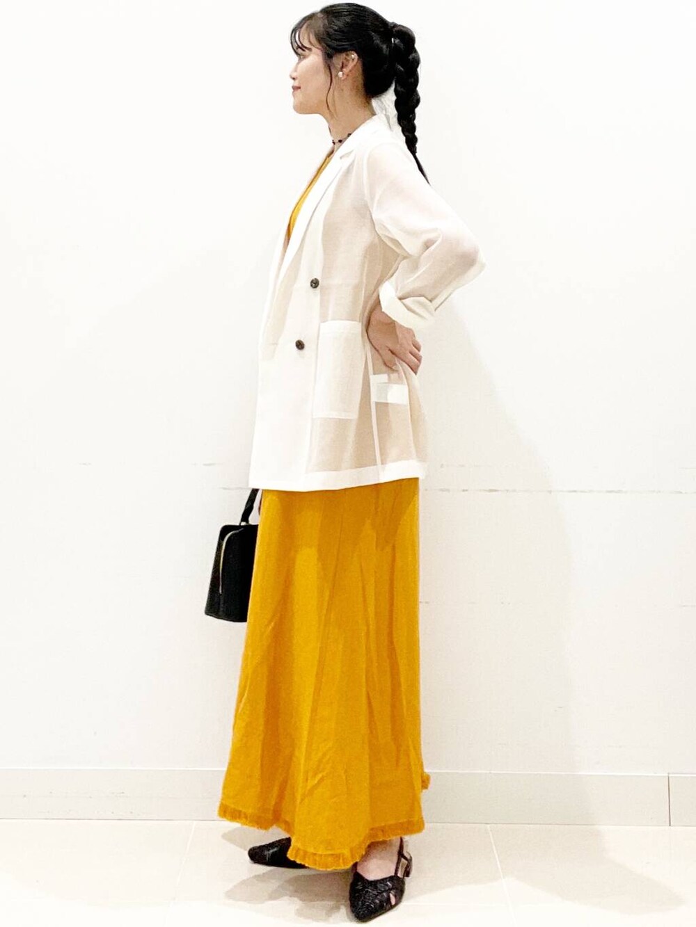 ブラック系のハンドバッグ、ブラック系のサンダル、ホワイト系のその他アウターを着用したレディースの夏コーディネートの6枚目の写真