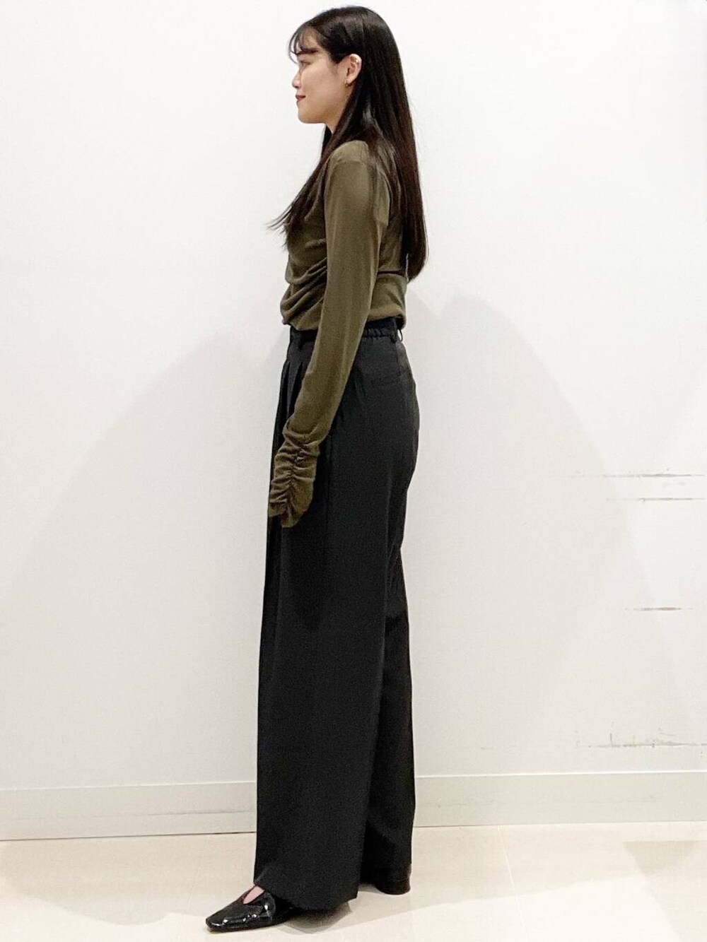 グレー系のその他パンツ、ブラック系のパンプス、ブラック系のハンドバッグを着用したレディースの春コーディネートの5枚目の写真