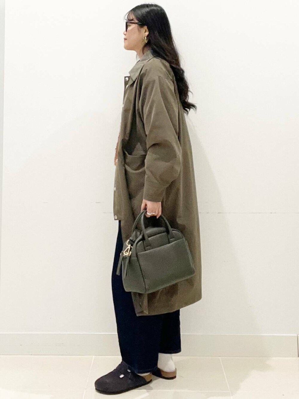 グリーン系のボストンバッグ、ブルー系のデニムパンツ、ブラウン系のその他アウターを着用したレディースの秋コーディネートの5枚目の写真