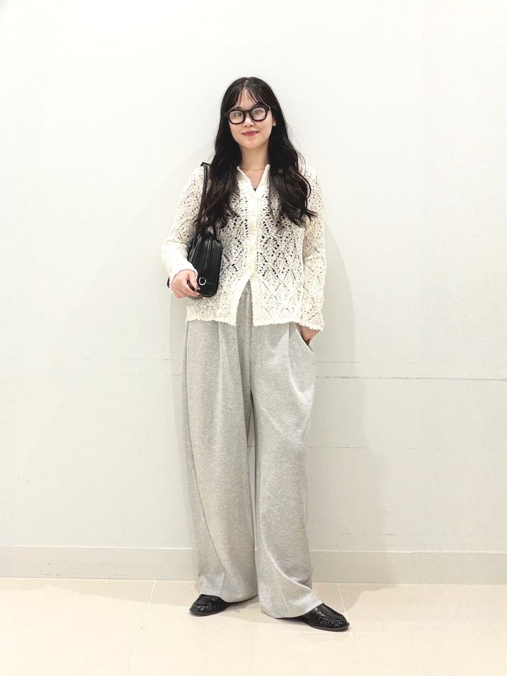 グレー系のその他パンツ、ホワイト系のニット/セーター、ブラック系のボストンバッグを着用したレディースの秋コーディネートの2枚目の写真