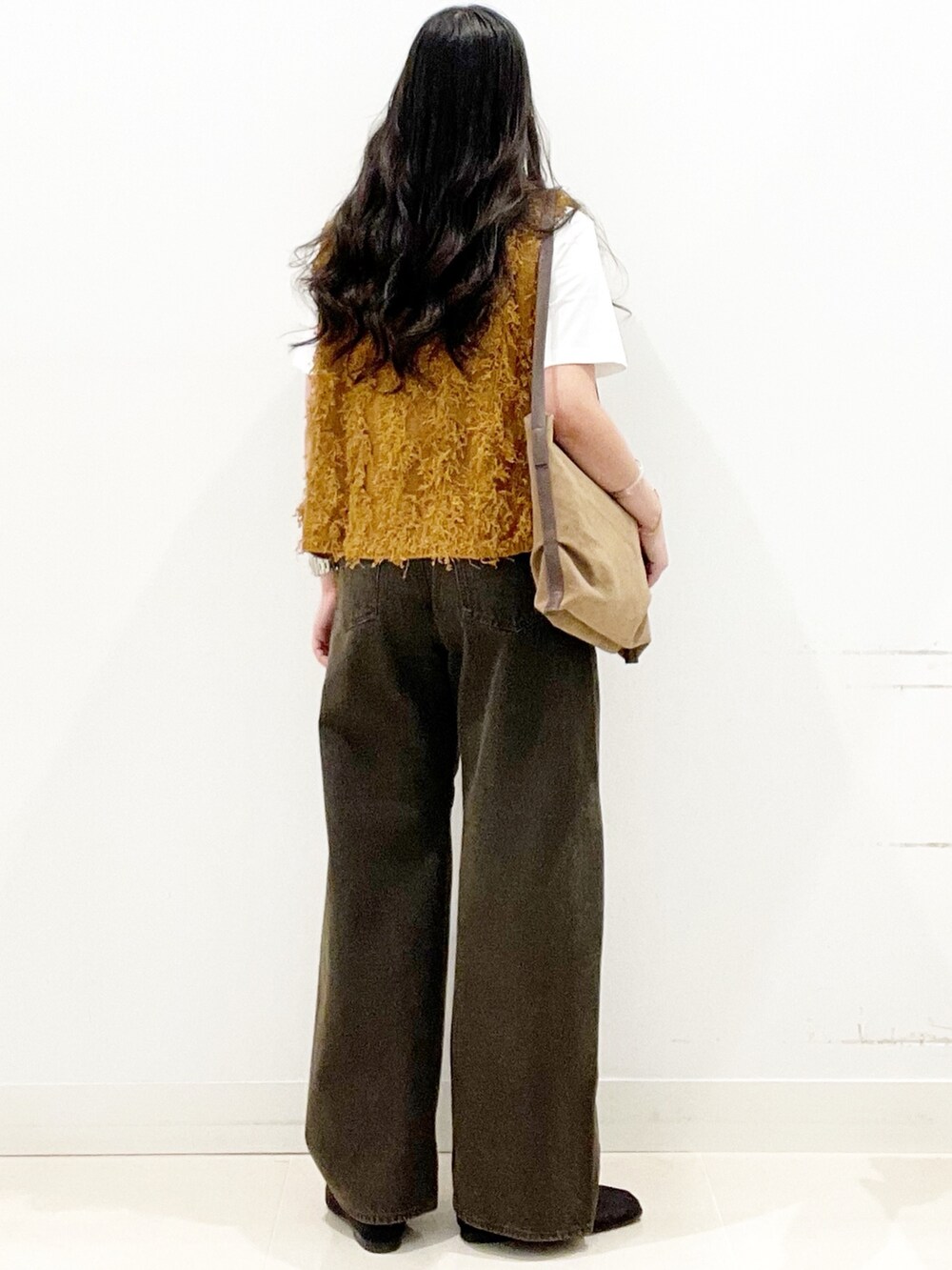 ブラック系のバレエシューズ、ブラウン系のデニムパンツ、ブラウン系のショルダーバッグを着用したレディースの秋コーディネートの5枚目の写真