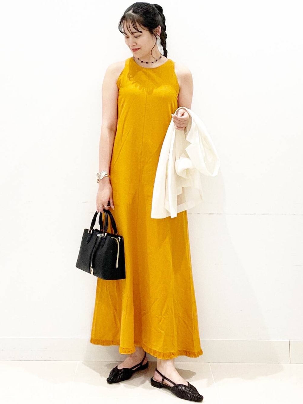 ブラック系のハンドバッグ、ブラック系のサンダル、ホワイト系のその他アウターを着用したレディースの夏コーディネートの5枚目の写真